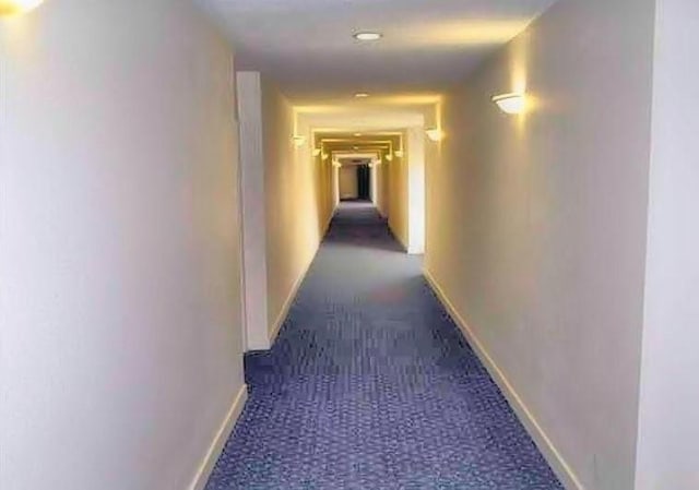 corridor with baseboards and carpet floors