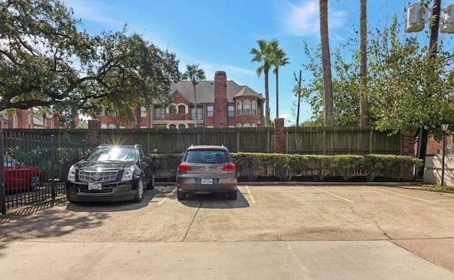 uncovered parking lot featuring fence