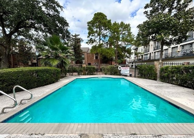 view of swimming pool featuring fence