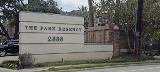 community / neighborhood sign featuring fence