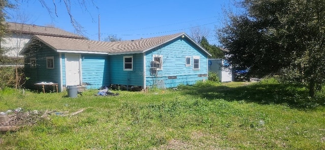 rear view of house featuring a yard