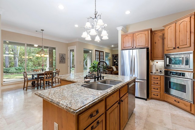 kitchen featuring light stone countertops, an island with sink, a notable chandelier, stainless steel appliances, and a sink