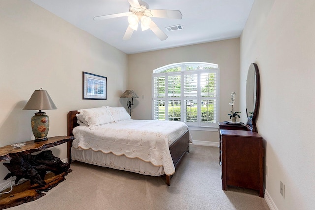 bedroom featuring a ceiling fan, visible vents, light colored carpet, and baseboards