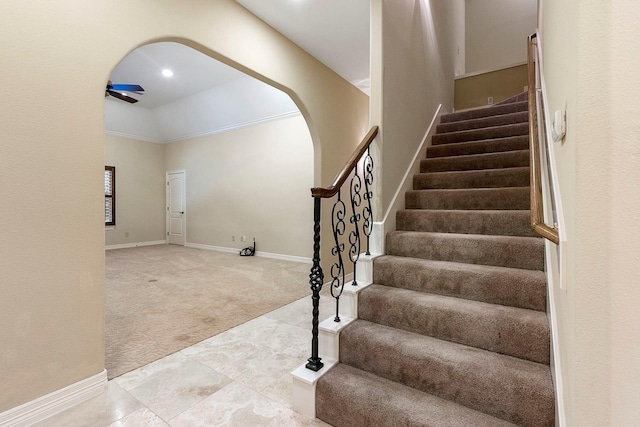 staircase with tile patterned flooring, baseboards, vaulted ceiling, carpet floors, and arched walkways