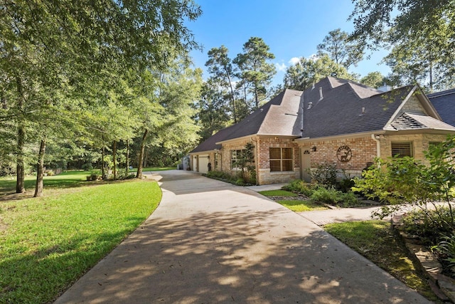 exterior space with a front yard, driveway, roof with shingles, a garage, and brick siding