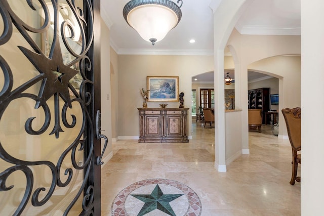 entryway with crown molding, arched walkways, and baseboards