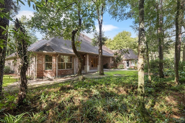 view of front of home featuring brick siding and a shingled roof