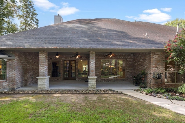 rear view of property with brick siding, french doors, a shingled roof, and a chimney