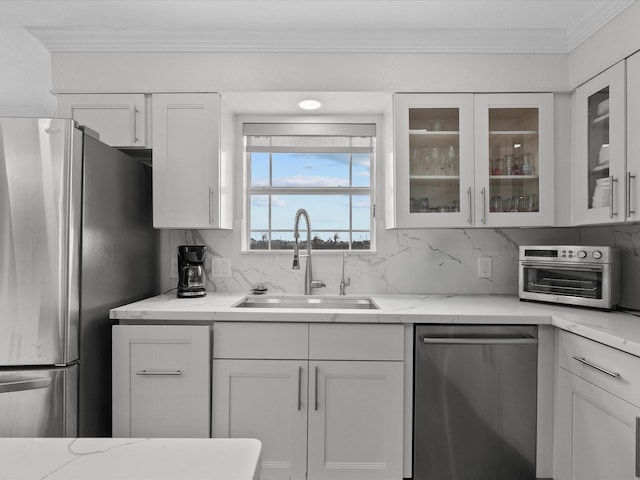 kitchen featuring a sink, backsplash, white cabinets, and appliances with stainless steel finishes