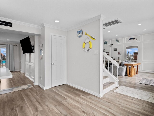 interior space featuring stairs, wood finished floors, ornamental molding, visible vents, and baseboards