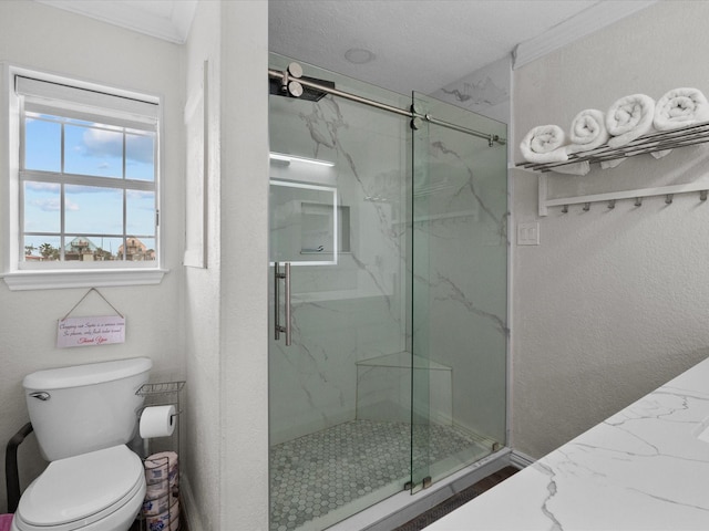 bathroom with a marble finish shower, ornamental molding, and toilet