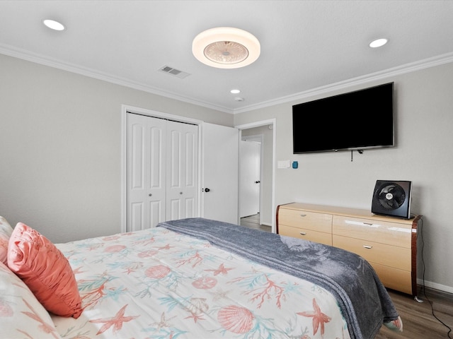bedroom featuring a closet, wood finished floors, ornamental molding, visible vents, and recessed lighting