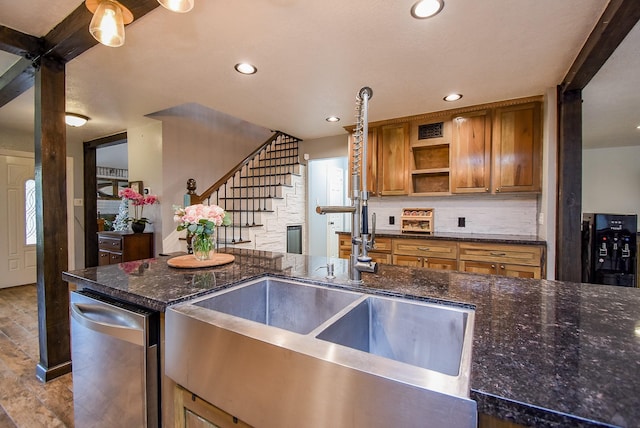 kitchen featuring wood finished floors, open shelves, a sink, brown cabinets, and backsplash