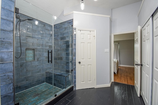 full bath with a shower stall, wood finished floors, and baseboards