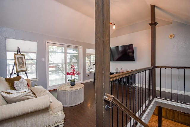 living room with baseboards, lofted ceiling, and wood finished floors