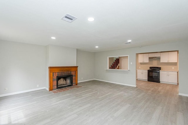 unfurnished living room featuring visible vents, baseboards, stairway, recessed lighting, and light wood-style floors