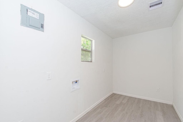 empty room featuring visible vents, baseboards, a textured ceiling, and light wood-style flooring