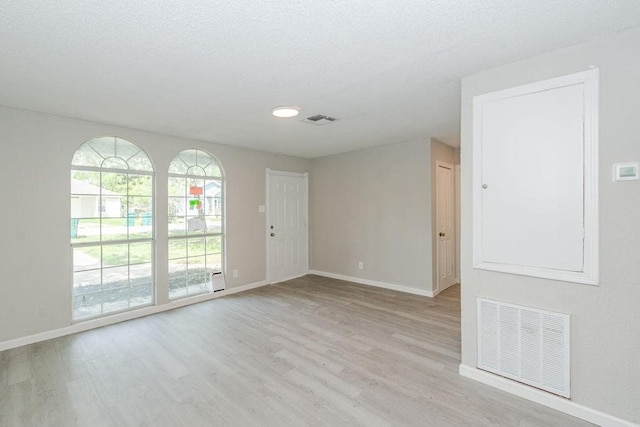 unfurnished room with visible vents, baseboards, and wood finished floors