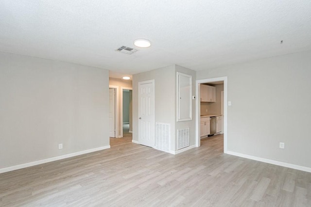 empty room featuring visible vents, baseboards, and light wood-style floors