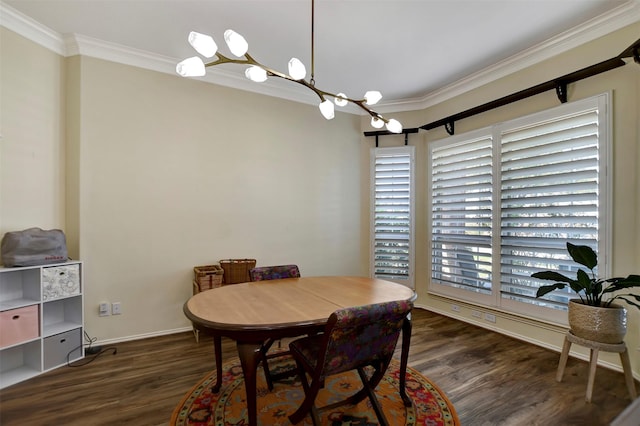 dining space featuring a chandelier, baseboards, wood finished floors, and crown molding