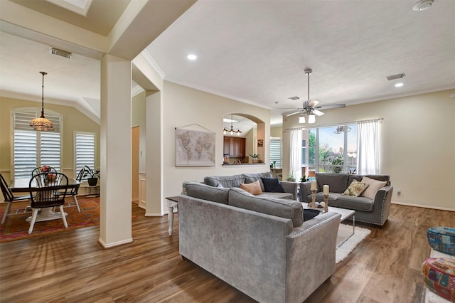 living room with a ceiling fan, wood finished floors, visible vents, and ornamental molding