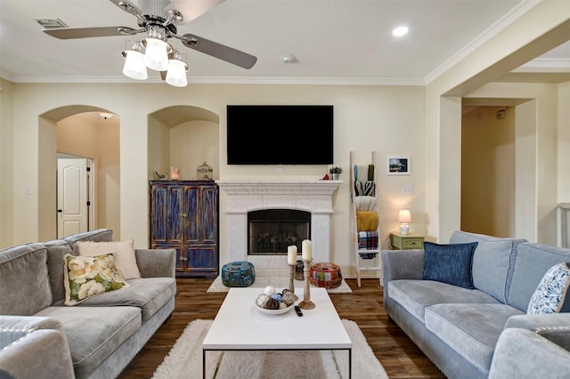 living area with dark wood finished floors, crown molding, a ceiling fan, and visible vents