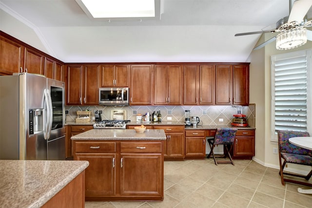 kitchen with tasteful backsplash, appliances with stainless steel finishes, and lofted ceiling