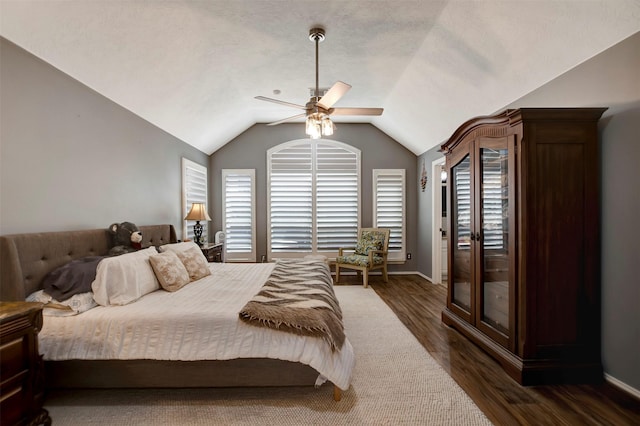 bedroom featuring a ceiling fan, baseboards, dark wood-type flooring, vaulted ceiling, and a textured ceiling