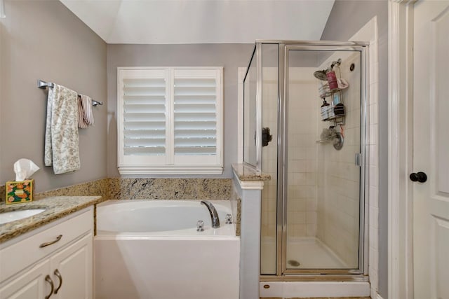 full bathroom featuring a garden tub, a stall shower, and vanity