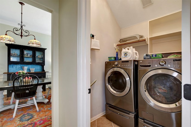 clothes washing area with visible vents, laundry area, separate washer and dryer, tile patterned floors, and a notable chandelier