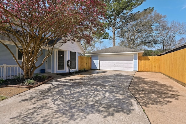 view of front of home featuring a detached garage, an outdoor structure, and fence