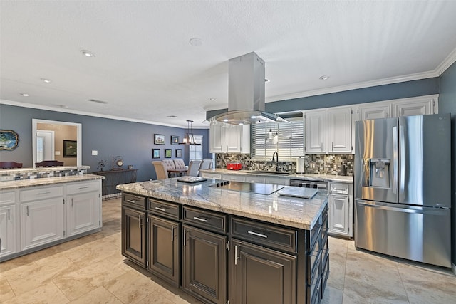 kitchen with island exhaust hood, a sink, white cabinetry, black electric cooktop, and stainless steel fridge