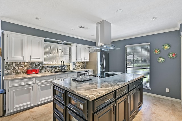 kitchen featuring visible vents, black appliances, a sink, island exhaust hood, and white cabinets