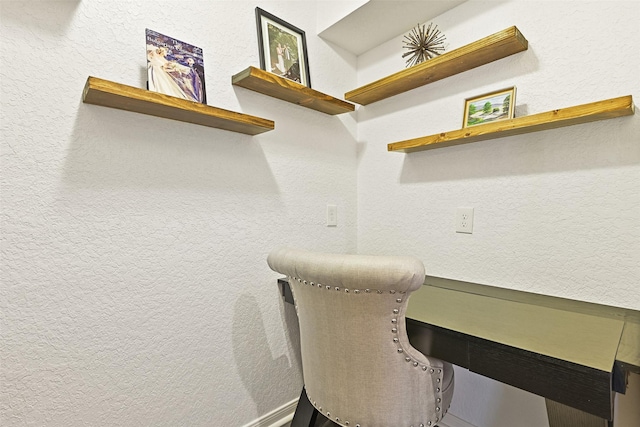 office area featuring a textured wall and built in desk