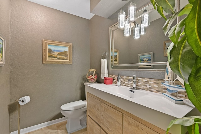 bathroom featuring vanity, baseboards, toilet, a textured wall, and backsplash