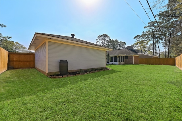 rear view of house featuring a yard and a fenced backyard