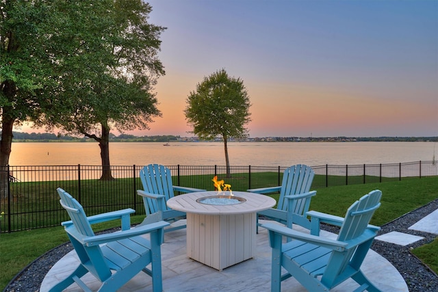 view of patio / terrace with an outdoor fire pit, a water view, and fence