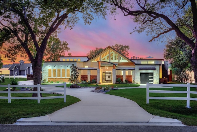 view of front of property with a fenced front yard, an attached garage, concrete driveway, and a front lawn