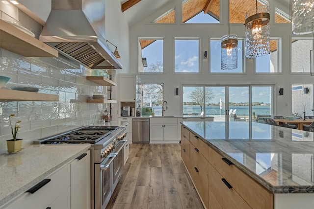 kitchen featuring open shelves, range hood, stainless steel appliances, light wood finished floors, and decorative backsplash