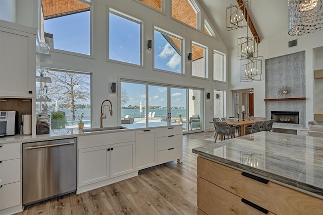 kitchen featuring visible vents, a notable chandelier, light wood-style flooring, a sink, and stainless steel dishwasher