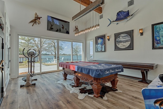 game room with visible vents, pool table, wood finished floors, and a towering ceiling