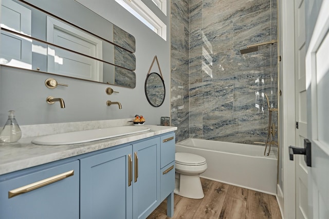 bathroom featuring tub / shower combination, toilet, vanity, and wood finished floors