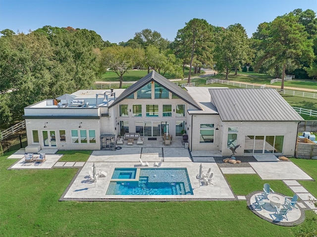 rear view of house featuring a patio, fence, a standing seam roof, a lawn, and metal roof