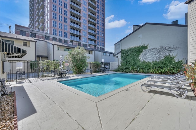 pool with a patio and fence