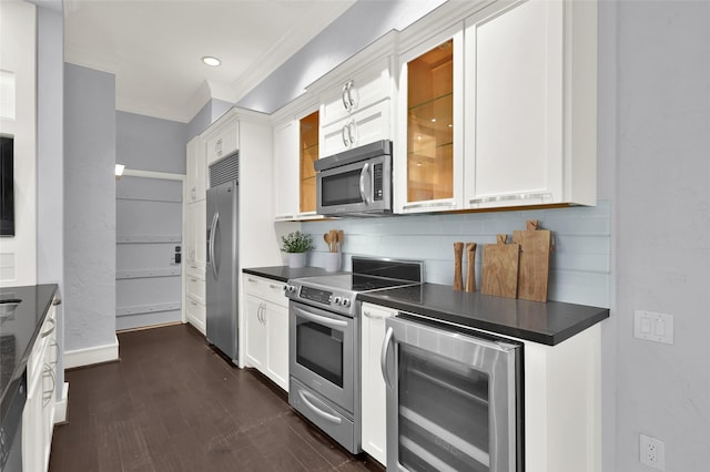 kitchen with dark countertops, white cabinetry, wine cooler, appliances with stainless steel finishes, and decorative backsplash