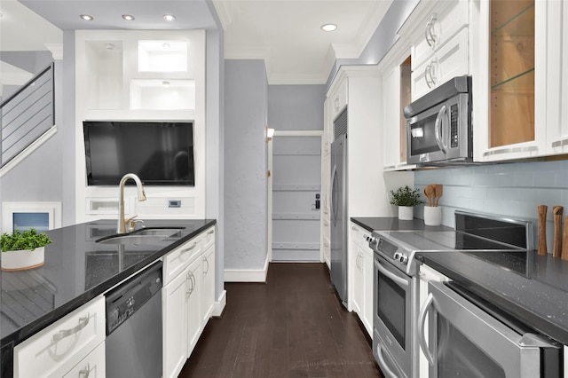 kitchen with a sink, dark stone countertops, white cabinetry, and stainless steel appliances