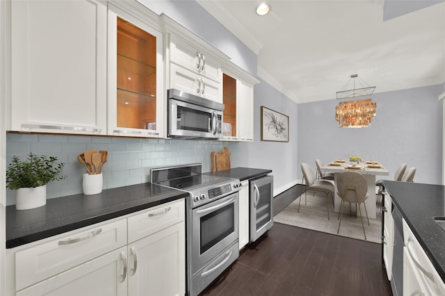 kitchen with appliances with stainless steel finishes, beverage cooler, white cabinets, and ornamental molding