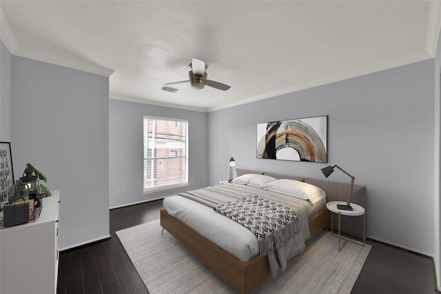 bedroom with visible vents, crown molding, ceiling fan, and wood finished floors