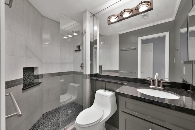 bathroom featuring vanity, toilet, a tile shower, and ornamental molding