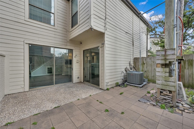 view of patio featuring central AC unit and fence